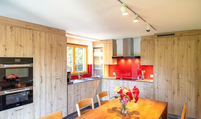 Küche in Eiche mit roter Glasrückwand
